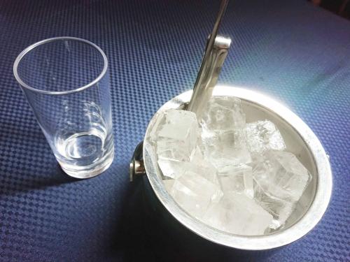 木更津的住宿－Hotel Royal Garden Kisarazu / Vacation STAY 72219，一杯水旁边一桶冰
