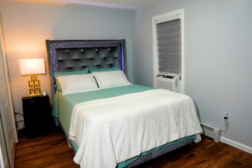 a bedroom with a large bed with a blue headboard at Serene Escape Leave Worries Behind in Wilkes-Barre