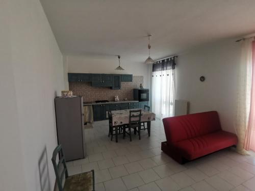 ein Wohnzimmer mit einem roten Sofa und einer Küche in der Unterkunft Appartamento Stella in San Benedetto del Tronto