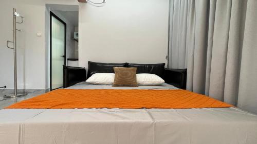 łóżko z pomarańczowym kocem na górze w obiekcie Xingyu Apartment - Tianhe Road w Guangzhou
