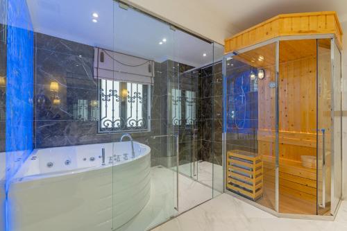 een badkamer met een bad en een glazen douche bij VILLA PARK in Kinh Dinh