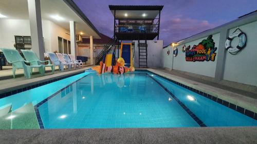 a large swimming pool with chairs and an indoor swimming pool at Family POOL VILLA CHAAM in Cha Am