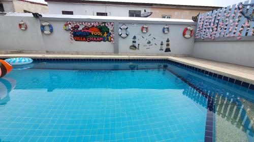 a large swimming pool with blue water in a building at Family POOL VILLA CHAAM in Cha Am