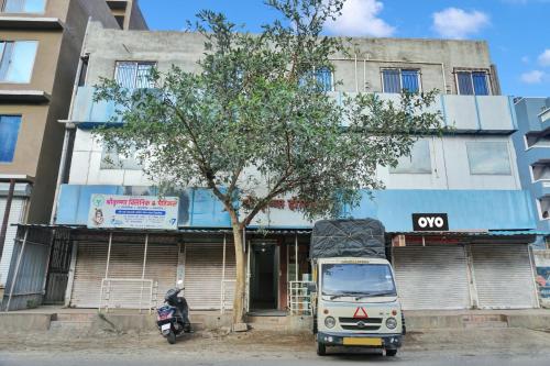 a truck parked in front of a building with a tree at OYO Flagship Hotel Classic Square in Pune