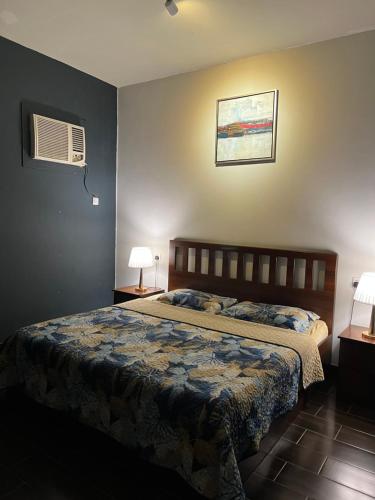 a bedroom with a bed and two lamps and a fan at Valley Villa in Jeddah