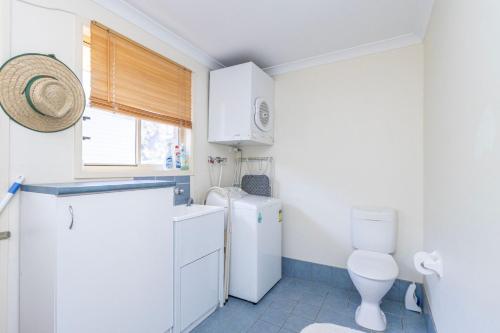 a small bathroom with a toilet and a sink at Holiday on the Water in Sussex Inlet
