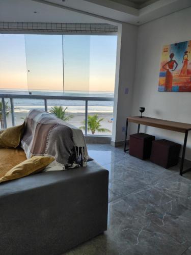 a bedroom with a bed and a view of the beach at Frente mar in Praia Grande