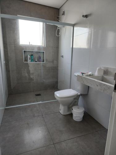 a bathroom with a shower and a toilet and a sink at Frente mar, pé na areia !! in Praia Grande