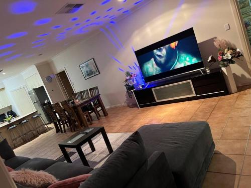 sala de estar con TV de pantalla plana grande en Private self check in home, en Alice Springs