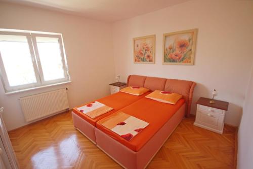 ein Schlafzimmer mit einem großen orangefarbenen Bett in einem Zimmer in der Unterkunft Apartment Maris with nice sea view in Ljubač
