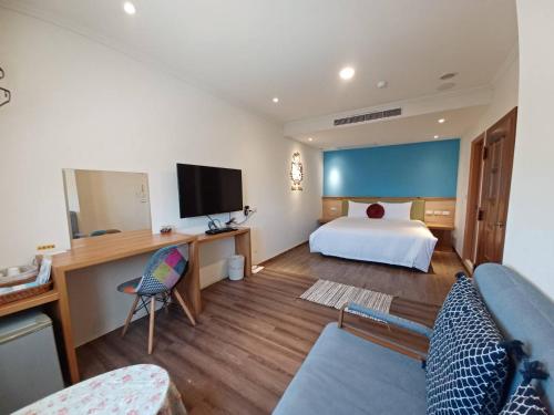 a hotel room with a bed and a flat screen tv at 陽光小灣旅店 in Kenting