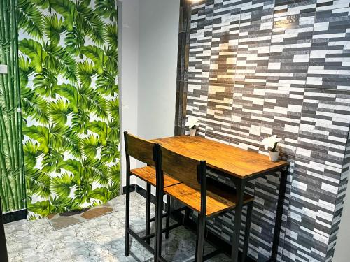 una mesa de madera con un banco junto a una pared en H&Q Bangtao Kitchen Studio, en Bang Tao Beach