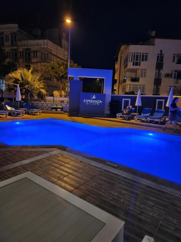 a swimming pool at night with chairs and umbrellas at Esperanza Hotel in Antalya