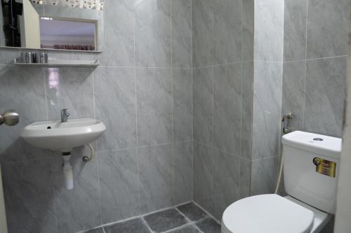 a bathroom with a white toilet and a sink at Empire House, Phnom Penh in Phnom Penh