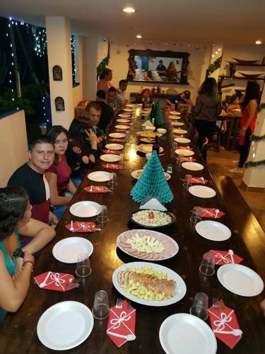 a group of people sitting around a long table with plates of food at Casa hotel villadiana in Armenia