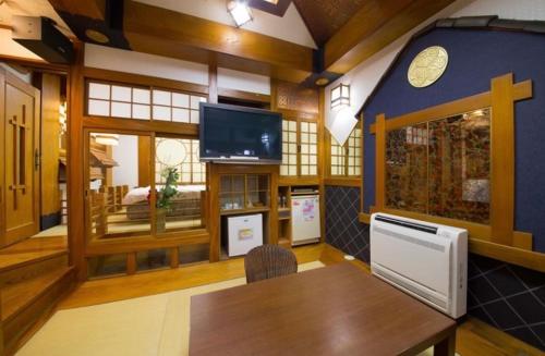 sala de estar con mesa y TV en ホテル　アイネ　香芝店, en Kashiba