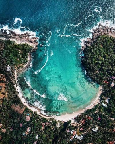 an aerial view of a beach and the ocean at Belika Beach in Hiriketiya