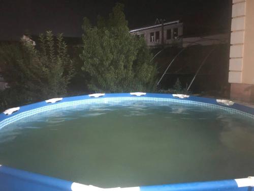 a large swimming pool in a yard at night at SAM GREEN HOUSE Hostel in Samarkand