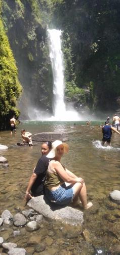 two people sitting on a rock in front of a waterfall at Las vegas lodge and restaurant in Banaue