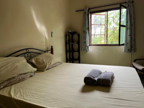 a bedroom with a bed with two towels on it at Boli Boli Guesthouse in Sere Kunda
