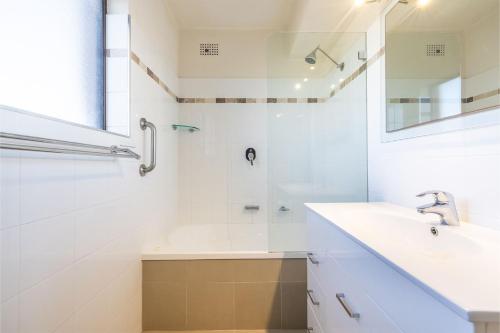 Un baño blanco con lavabo y ducha en Intrepid, 15 3 Intrepid Close - right on the beachfront and WiFi, en Shoal Bay