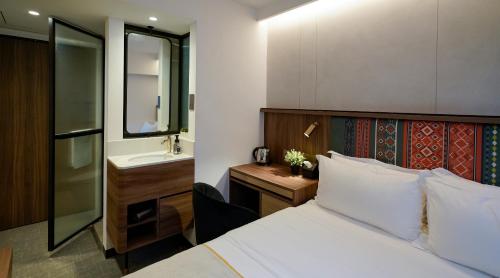 a hotel room with a bed and a sink at ST Signature Bugis Middle in Singapore