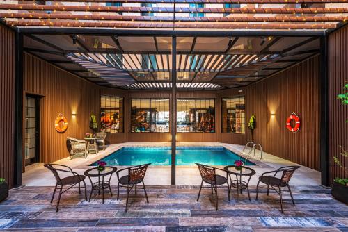 an indoor pool with tables and chairs and a pool at Beach View Hotel in Dammam