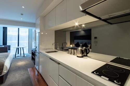 a kitchen with a sink and a stove top oven at The Vale Niseko in Kutchan