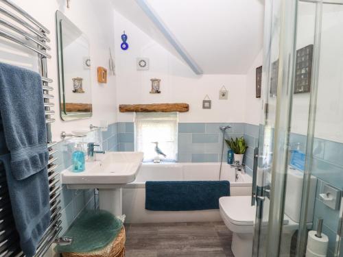 a bathroom with a sink and a tub and a toilet at Fell Cottage in Wigton