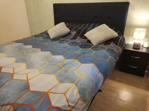 1 dormitorio con 1 cama grande y colcha colorida en F3 plein centre ville de Gien, en Gien