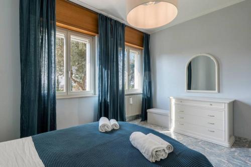 una camera da letto con un letto blu e asciugamani di BERNY s countryside retreat a Lonato