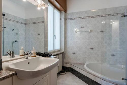 bagno con lavandino, vasca, lavandino e specchio di BERNY s countryside retreat a Lonato
