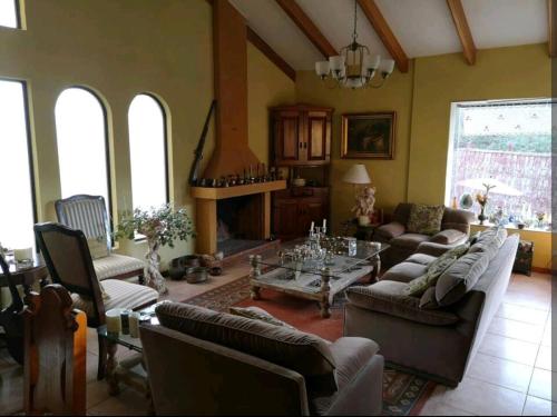 uma grande sala de estar com sofás e uma lareira em Habitación matrimonial deluxe Casa Tierra Elquina em Vicuña