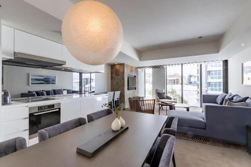 a kitchen and living room with a table and chairs at The Vale Niseko in Kutchan
