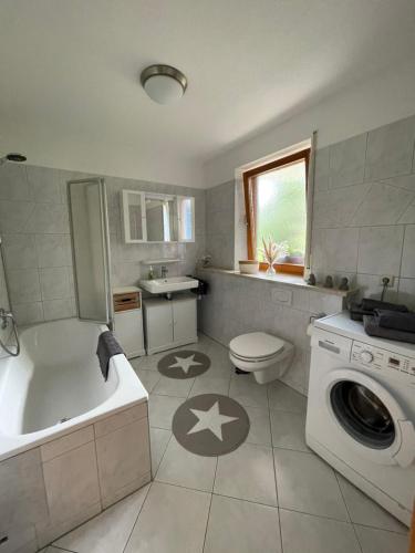 een badkamer met een bad, een toilet en een wastafel bij Schwarzwald - Schöne, ruhige Auszeit in der FeWo - Im Grünen in Weilheim