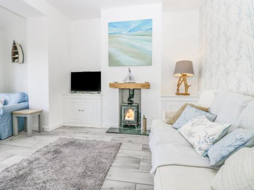 a living room with a couch and a fireplace at Driftwood Cottage Roa Island Piel Island in Barrow in Furness