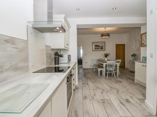 a kitchen with white cabinets and a counter top at Driftwood Cottage Roa Island Piel Island in Barrow in Furness