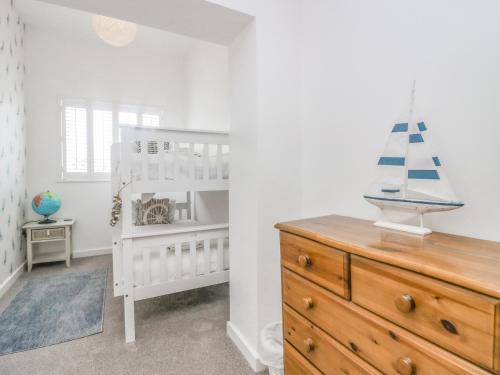 a baby room with a crib and a dresser at Driftwood Cottage Roa Island Piel Island in Barrow in Furness