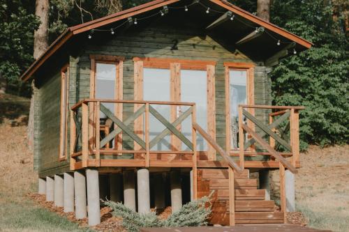 a tiny house with a porch and a deck at Orupõhja kämpingud ja telkimisala in Põlva