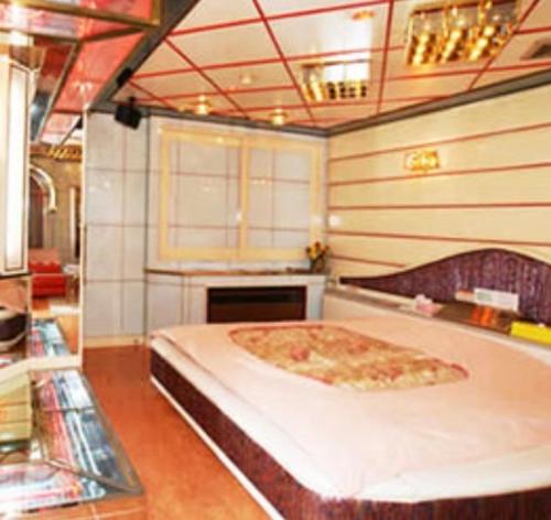 a room with a bed with a large pizza on it at ホテル　アイネ　五條店 in Nohara