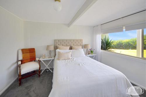 Cape Bridgewater的住宿－Cape Villa，卧室配有床、椅子和窗户。