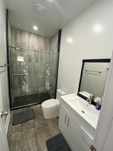y baño con ducha, aseo y lavamanos. en Oshawa Downtown, 2 Bed rooms house fully furnished en Oshawa