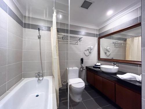 a bathroom with a tub and a toilet and a sink at Damai Lagoon Resort in Santubong