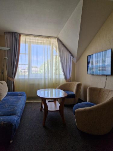 a living room with a couch and a coffee table at Hotel Linda - Helvita in Liepāja