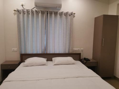1 cama con 2 almohadas en un dormitorio con ventana en The36Inn, en Visakhapatnam