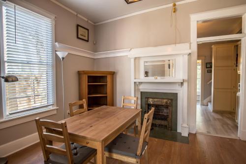 a dining room with a wooden table and a fireplace at Southern Sophistication and Charm in the Heart of Cooper Young in Memphis