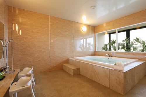 a bathroom with a large tub and a window at Hotel Montoview Yonezawa in Yonezawa