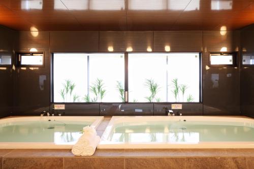 a jacuzzi tub in a bathroom with a large window at Hotel Montoview Yonezawa in Yonezawa
