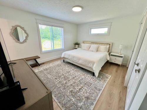 a bedroom with a bed and a window and a rug at Dream Palace with HOT TUB-Game Room-Fire Pit-5BR-3BA in Traverse City