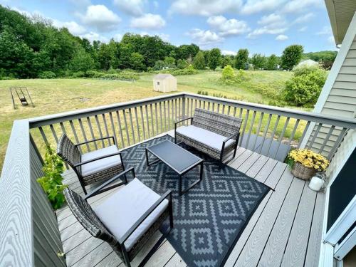 a deck with chairs and a table and chairs at Dream Palace with HOT TUB-Game Room-Fire Pit-5BR-3BA in Traverse City